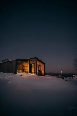 a small house in the snow at night at Stare Szałasy z widokiem na Tatry, sauna, jacuzzi, rowery in Klikuszowa