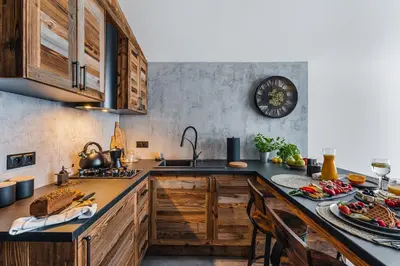 a kitchen with wooden cabinets and a counter with food on it at Stare Szałasy z widokiem na Tatry, sauna, jacuzzi, rowery in Klikuszowa