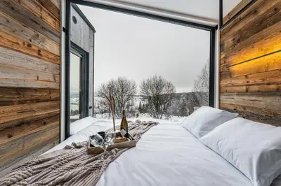 two beds in a room with a large window at Stare Szałasy z widokiem na Tatry, sauna, jacuzzi, rowery in Klikuszowa
