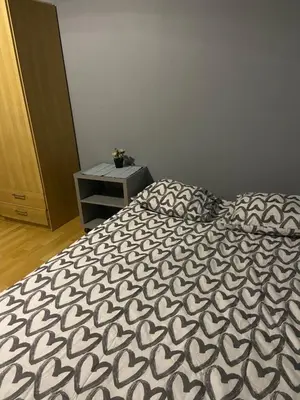 a bed with a black and white comforter in a bedroom at Centrum Apart in Kraków