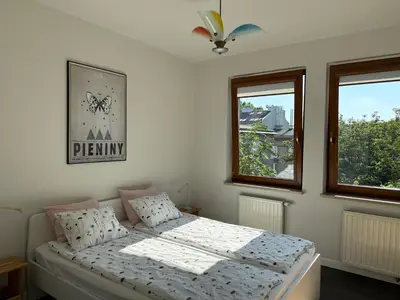 a bedroom with a bed and two windows at Modern House in Old Town Numero 8 in Kraków