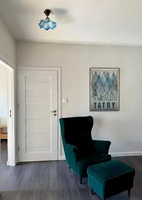 a living room with a green chair and a stool at Modern House in Old Town Numero 8 in Kraków