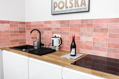 a kitchen counter with a sink and a bottle of wine at Modern House in Old Town Numero 8 in Kraków