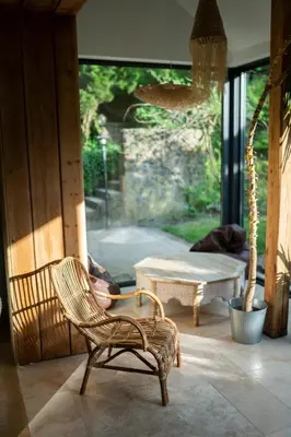 a room with a chair and a table and a window at BlissHouse Luxurious Guesthouse calm and energetic spot near by city surrounded by the forest where you will find your peace and your people in Kraków