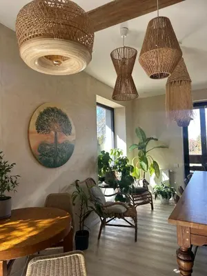 a living room with a table and chairs and potted plants at BlissHouse Luxurious Guesthouse calm and energetic spot near by city surrounded by the forest where you will find your peace and your people in Kraków