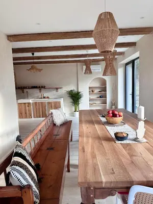 a dining room with a wooden table with a bowl of fruit at BlissHouse Luxurious Guesthouse calm and energetic spot near by city surrounded by the forest where you will find your peace and your people in Kraków