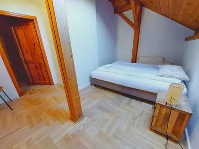 a small bedroom with a bed and a wooden floor at BlissHouse Luxurious Guesthouse calm and energetic spot near by city surrounded by the forest where you will find your peace and your people in Kraków
