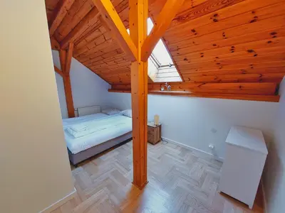 a attic room with a bed and a wooden ceiling at BlissHouse Luxurious Guesthouse calm and energetic spot near by city surrounded by the forest where you will find your peace and your people in Kraków