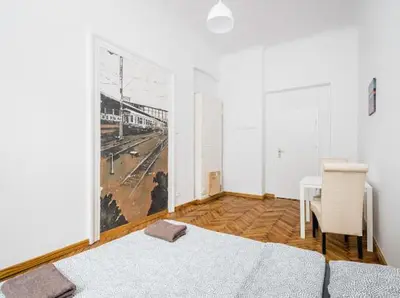 a bedroom with a bed and a table and a window at Szczebel in Kraków