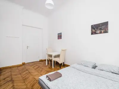a bedroom with a table and a bed and a table and chairs at Szczebel in Kraków