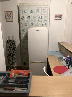 a kitchen with a refrigerator and a table and a counter at Szczebel in Kraków
