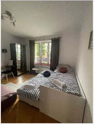 a bedroom with two beds and a wooden floor at Cheerful 3 bedroom city house in Kraków