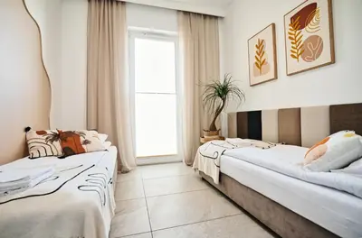 two beds in a room with a window at Apartament Nairobi by Housine in Zator