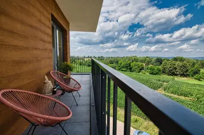 a balcony with two chairs and a view of a vineyard at Apartament Nairobi by Housine in Zator