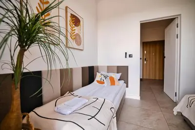 a bedroom with two beds and a potted plant at Apartament Nairobi by Housine in Zator