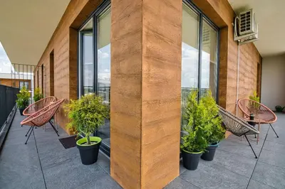 a balcony with chairs and plants in a building at Apartament Nairobi by Housine in Zator