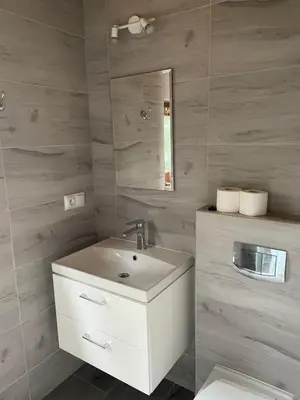 a bathroom with a white sink and a mirror at Apartament Sosnowy Domek Piętro Zator Graboszyce in Graboszyce