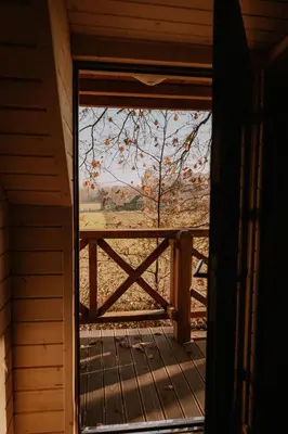 an open door to a porch with a view of a fence at Apartament Sosnowy Domek Piętro Zator Graboszyce in Graboszyce