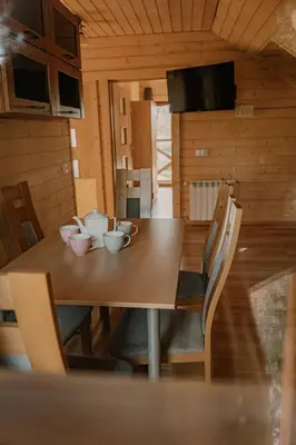 a dining room table with bowls and cups on it at Apartament Sosnowy Domek Piętro Zator Graboszyce in Graboszyce