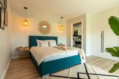 a bedroom with a blue bed and a mirror at Lamelove Apartments - Energylandia, Zator in Chocznia