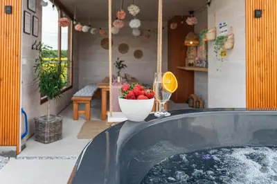 a tub with a bowl of fruit and a glass of wine at Lamelove Apartments - Energylandia, Zator in Chocznia