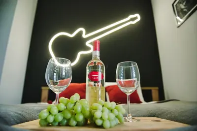 a bottle of wine and two glasses on a table with grapes at Blues Room by Housine in Zator