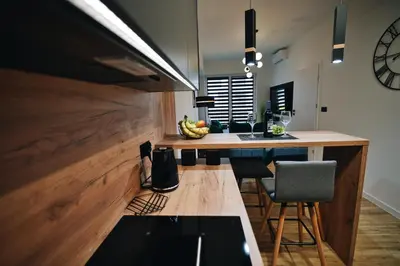 a kitchen with a counter and a table with chairs at ApartHome 25 by Housine in Zator