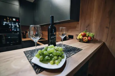 a bottle of wine and a plate of grapes on a counter at ApartHome 25 by Housine in Zator