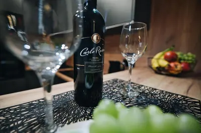 a bottle of wine sitting on a table with two glasses at ApartHome 25 by Housine in Zator