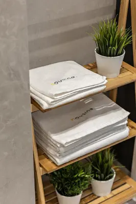 a stack of towels on a shelf with potted plants at Artis Apartments by Housine in Zator