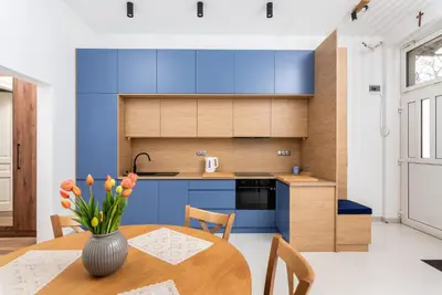 a kitchen with blue cabinets and a wooden table at Premium Splendid Old Town Suites - by Upstairs in Kraków