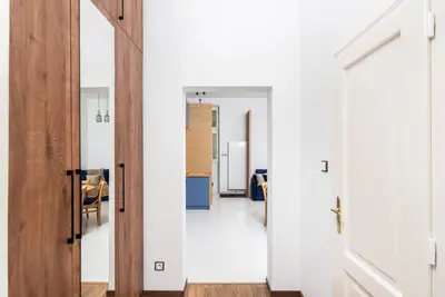 a hallway with white walls and a wooden door at Premium Splendid Old Town Suites - by Upstairs in Kraków