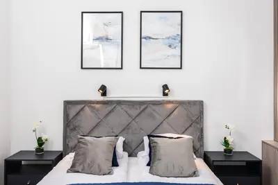 a bedroom with a large bed with three pictures on the wall at Premium Splendid Old Town Suites - by Upstairs in Kraków