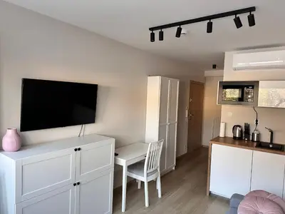 a living room with a white desk and a tv at Apartament Xavier Kraków in Kraków
