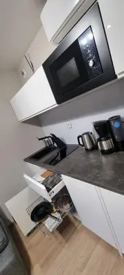 a kitchen with a counter top with a microwave at Apartament Xavier Kraków in Kraków