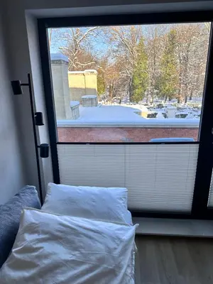 a bedroom with a large window with a white bed at Apartament Xavier Kraków in Kraków