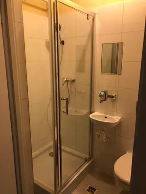 a bathroom with a shower with a sink and a toilet at CASIO in Kraków