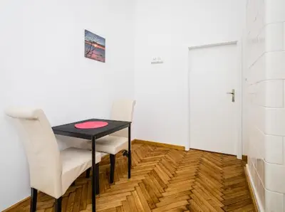 a dining room table with two chairs and a door at CASIO in Kraków