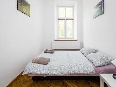 a bed in a white room with a window at CASIO in Kraków