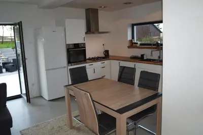 a kitchen with a table and chairs in a room at Panorama Racławicka Domek Willa Basen Agroturystyka in Janowiczki