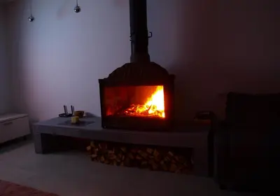 a fireplace in a living room with a fire in it at Panorama Racławicka Domek Willa Basen Agroturystyka in Janowiczki