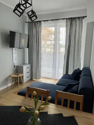 a living room with a blue couch in front of a window at Apartament Marko Due in Zator