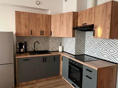 a kitchen with wooden cabinets and a black appliance at Apartament Marko Due in Zator
