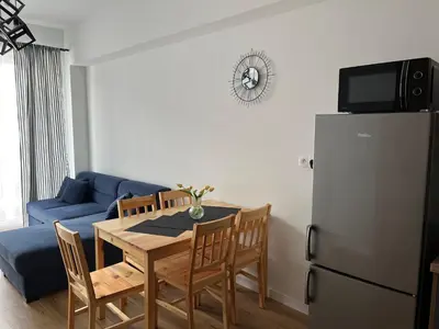 a living room with a table and a refrigerator at Apartament Marko Due in Zator