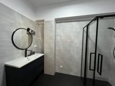 a bathroom with a sink and a shower with a mirror at Apartament Marko Due in Zator