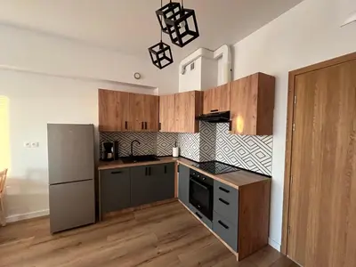 a kitchen with wooden cabinets and a refrigerator at Apartament Marko Due in Zator
