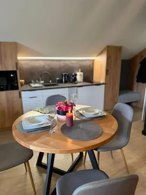 a dining room table with chairs and a kitchen at Secret House Zator in Zator