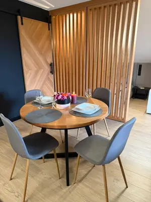 a wooden table with chairs and a wooden wall at Secret House Zator in Zator