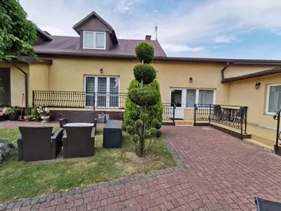a house with a table and chairs in the yard at Agrostrzecha in Ryczów