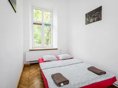 a bedroom with two beds and a window at Wąsik in Kraków